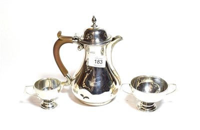Lot 183 - A George V silver hot water jug and associated cream jug and sugar bowl, the hot water jug by...