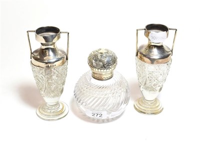 Lot 272 - A pair of silver mounted cut glass silver vases together with a silver mounted cut glass bottle (3)