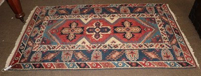 Lot 1006 - A Yagibedir rug, the brick red field with three cruciform medallions, indigo borders, 195cm by...