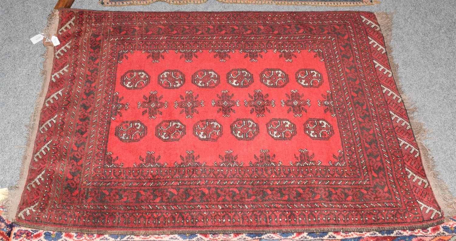 Lot 1015 - A Turkmen rug, the scarlet field with two rows of guls enclosed by narrow borders, 133cm by 102cm