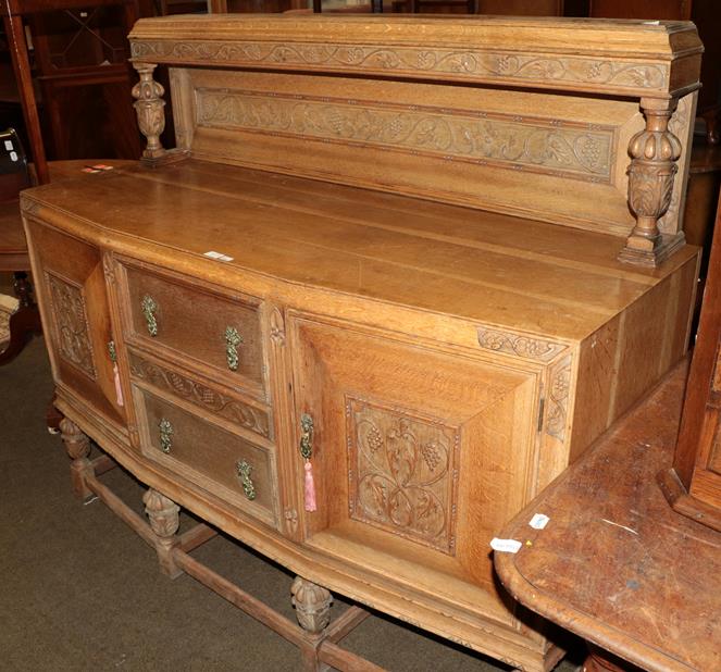 Lot 1171 - An early 20th century carved oak buffet back sideboard with pineapple carved legs