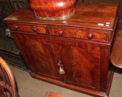 Lot 1185 - An early Victorian figured mahogany side cabinet, with two frieze drawers, turned handles above...