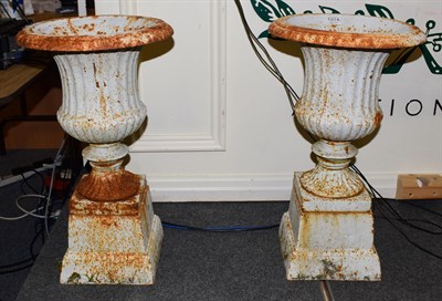 Lot 1314 - A pair of painted cast iron campana shaped garden urns on pedestals (2)