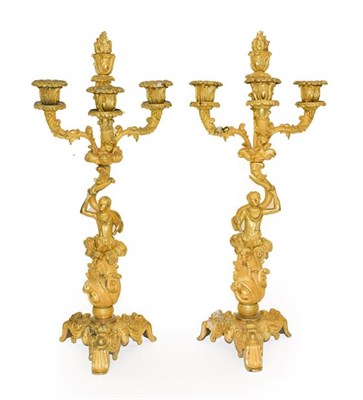 Lot 147 - A Pair of Gilt Bronze Four-Light Figural Candelabra, in Louis XV style, with flammiform finial...