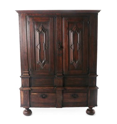 Lot 174 - An Oak Cupboard, the moulded canopy above fielded cupboard doors enclosing later hooks and pegs, on
