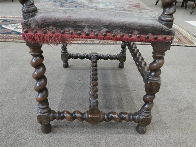 Lot 187 - A Late 17th Century Carved Walnut Armchair, covered in close-nailed floral needlework fabric,...