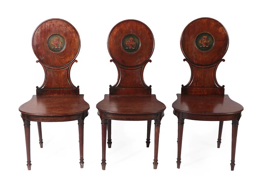 Lot 198 - A Set of Three George III Mahogany Hall Chairs, late 18th century, each with circular and C...