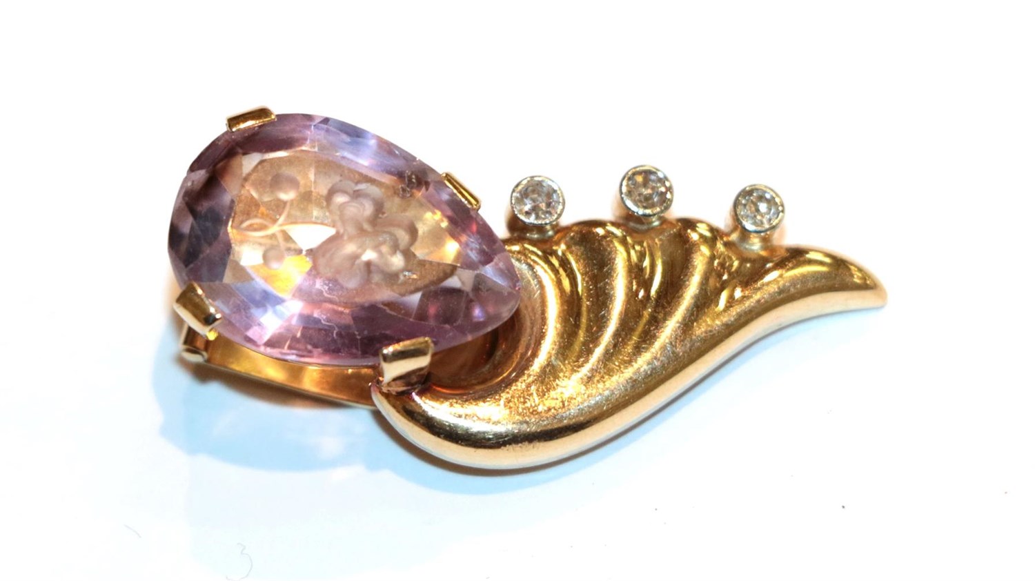 Lot 86 - An amethyst intaglio and diamond clip, length 3.5cm