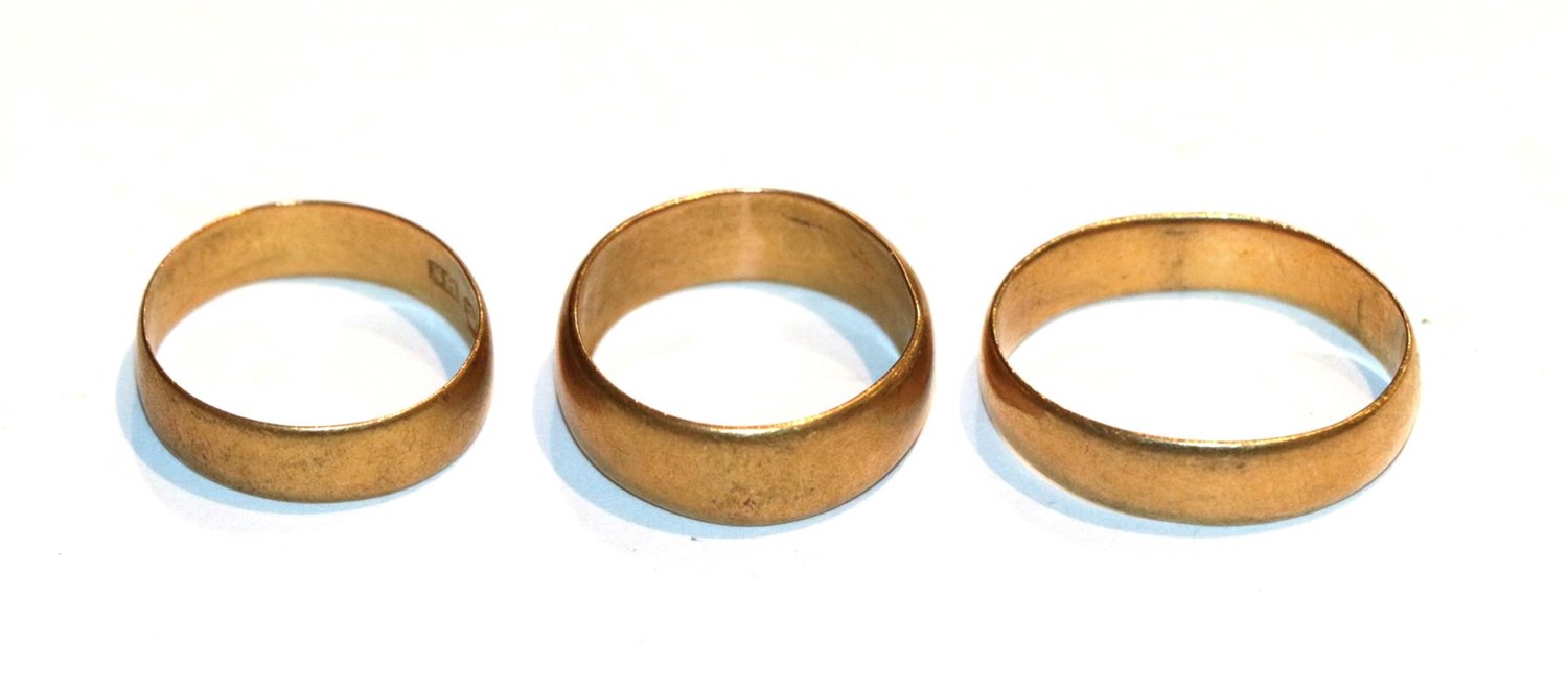 Lot 129 - Three 22 carat gold band rings, out of shape