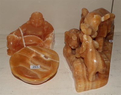 Lot 251 - Three orange calcite figures comprising elephant figure group, Buddha and an alter dish