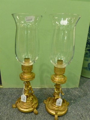 Lot 1126 - A Pair of French Ormolu Figural Candlesticks with Storm Shades, circa 1870 and later adapted,...