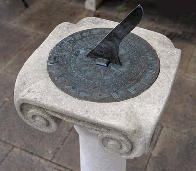 Lot 1142 - A Natural Stone Ionic Pedestal, of recent date, the top with inset modern bronze sundial plate,...