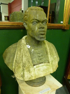 Lot 1146 - A Carved Stone and Marble Figure of a Negro, bust length, with forward gaze, upon a concave...