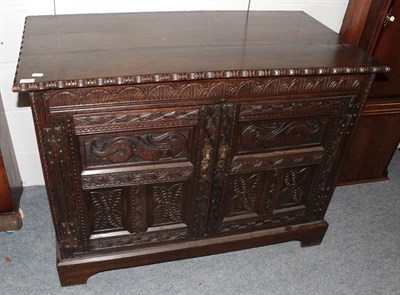 Lot 1242 - A carved oak cupboard, 18th century in part, with two carved cupboard doors, raised on a later...