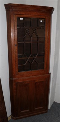 Lot 1244 - An early 19th century oak double corner cupboard