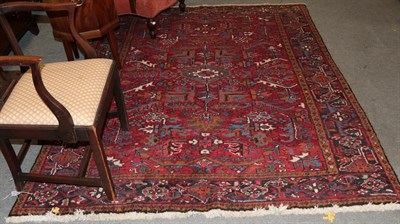 Lot 1270 - A Heriz rug, the aubergine field of angular vine enclosed by samovar borders, 235cm by 181cm