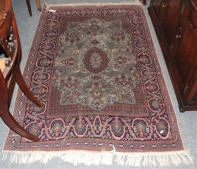 Lot 1273 - A Indian rug the ivory field of urns issuing flowers around a medallion framed by meandering...