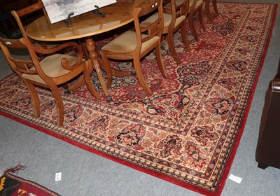 Lot 1275 - A machine made carpet of Oriental design, the terracotta field with central medallion framed by...