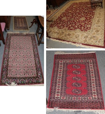 Lot 1278 - An Indian carpet, the deep brick red field of scrolling vines enclosed by ivory borders, 378cm...