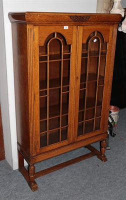 Lot 1297 - A 1920's oak bookcase and a matching bureau