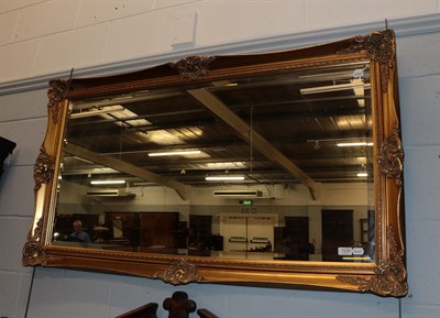 Lot 1339 - A reproduction gilt framed bevel glass mirror, 77cm by 136cm