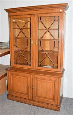 Lot 1351 - A late Victorian oak bookcase with dentil cornice above astragal glazed doors, the base with...