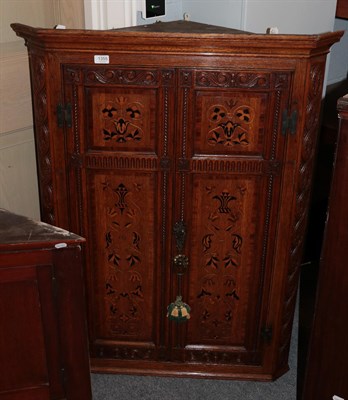 Lot 1355 - A late 19th century carved oak and marquetry inlaid hanging corner cupboard