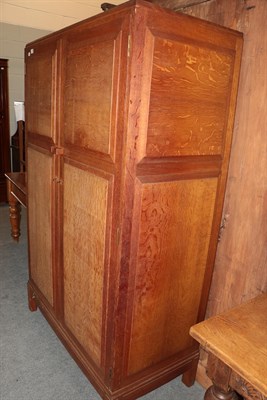 Lot 1359 - A utility oak two-door wardrobe, the interior with five sliding trays and hanging space, 111cm...