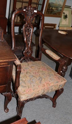 Lot 1390 - A carved walnut armchair in the 17th century style, with carved hoof feet, joined by a...