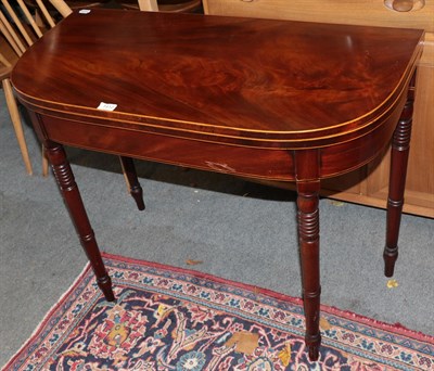 Lot 1412 - A George IV mahogany D-shaped fold-over card table on turned legs, 92cm by 45cm by 73cm