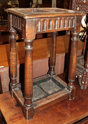 Lot 1432 - An oak two-division stick-stand with a drip-tray in the form of a joint stool