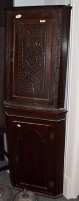 Lot 1443 - A George III carved oak corner cupboard; and a George III oak corner cupboard with panelled...