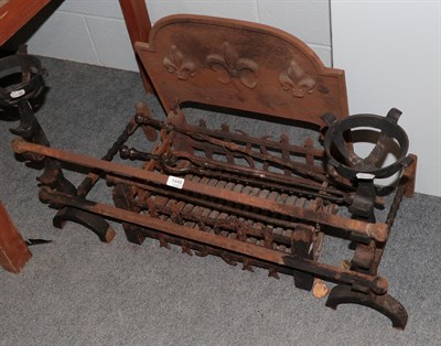 Lot 1449 - A cast iron fire grate, andirons and tools, the grate decorated with fleur de lis