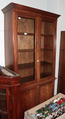 Lot 1452 - A mahogany glazed bookcase with adjustable shelves and cupboard doors, 91cm by 40cm by 202cm; and a