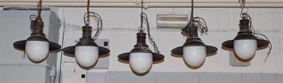 Lot 1469 - A set of five industrial design pendant ceiling lights each with opaque dome glass and blued...