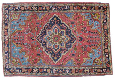 Lot 1247 - Saroukh Rug West Persia The soft strawberry field of angular vines around an indigo medallion...