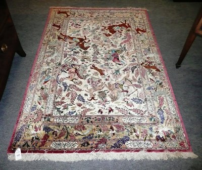 Lot 1265 - Fine Ghom Silk Rug Central Persia The ivory field depicting classical Persian hunting scenes...