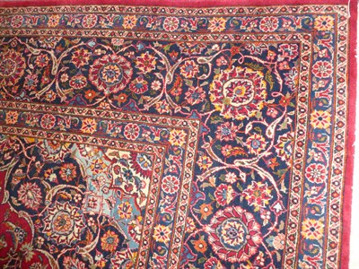 Lot 1270 - Kashan Carpet Central Persia The raspberry field of scrolling floral vines around an indigo...