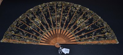 Lot 5161 - A Large Late 19th Century Wood Fan, the pale tan monture elaborately carved with exotic flowers and