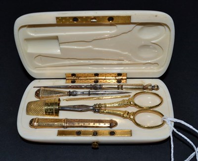 Lot 5326 - A Gilt Metal Sewing Set presented in an elegant oval ivory case, unlined but shaped to take the...