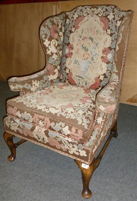 Lot 1391 - An Early 20th Century Queen Anne Style Wing Back Chair, upholstered in floral and petit point...