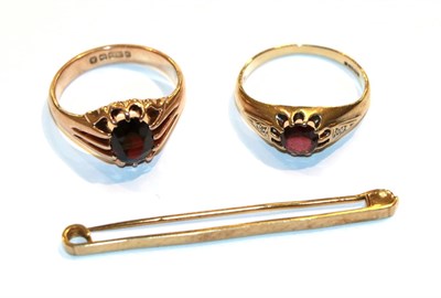 Lot 16 - Two 9 carat gold garnet rings, finger sizes R and S and a 9 carat gold bar brooch