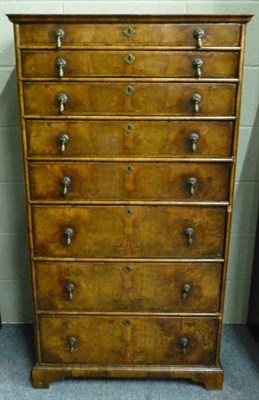 Lot 1432 - A Walnut Tall Chest of Drawers, the moulded top above an arrangement of feather banded...