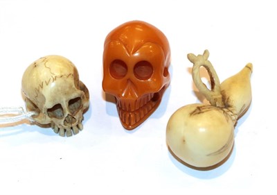 Lot 123 - Japanese ivory netsuke as a skull, 2cm high, another as a gourd and an amber skull, 2.3cm high (3)
