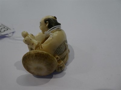 Lot 133 - Japanese ivory netsuke, man with glove puppet, 3cm high