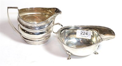Lot 224 - A George III silver cream jug, marks worn, circa 1800, helmet shaped and with angular handle,...