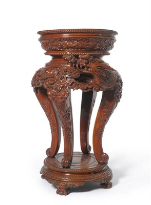 Lot 1448 - A 20th Century Chinese Carved Mahogany Plant Stand, the circular top above a gadrooned border,...