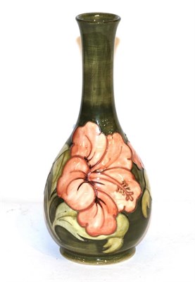 Lot 298 - A Walter Moorcroft bottle vase, coral hibiscus pattern on green, 26cm high