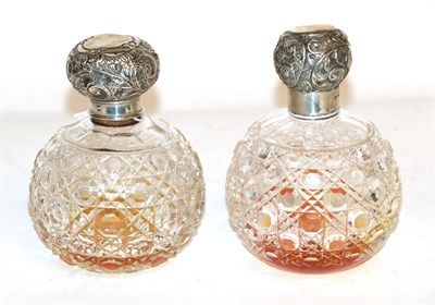 Lot 299 - Two silver-mounted cut-glass scent-bottles, each globular and cut with hobnails, the covers...