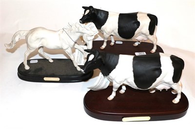 Lot 303 - Royal Doulton Horse 'Spirit of Life' together with two Friesian cow models, on wooden plinths (3)